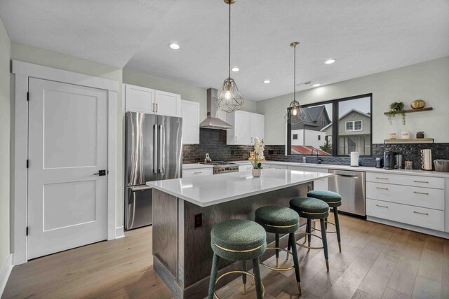 362-366 Zimpfer St Unit 1-3, Columbus, OH 43206 - kitchen with appliances with stainless steel finishes, wall chimney exhaust hood, light wood-type flooring, a center island, and backsplash