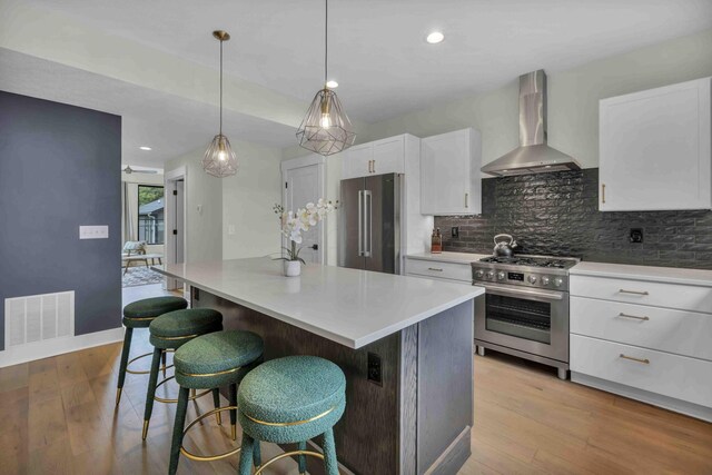 362-366 Zimpfer St Unit 1-3, Columbus, OH 43206 - kitchen with wall chimney exhaust hood, stainless steel appliances, backsplash, white cabinetry, and recessed lighting