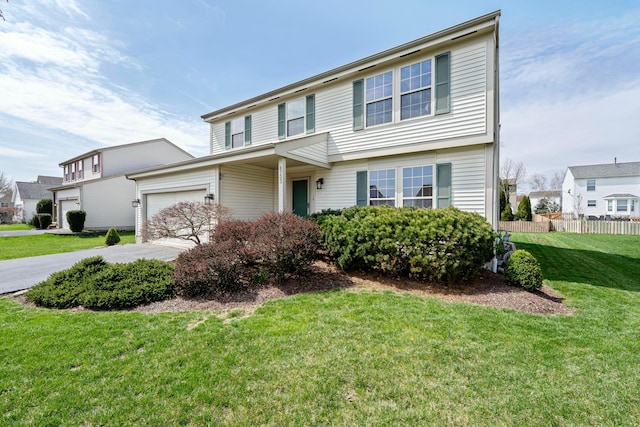 view of front of property with concrete driveway, a front yard, fence, and an attached garage