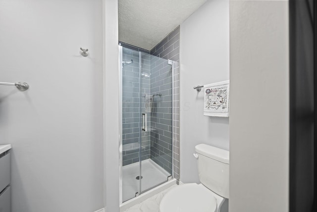 bathroom with toilet, a shower stall, vanity, and a textured ceiling