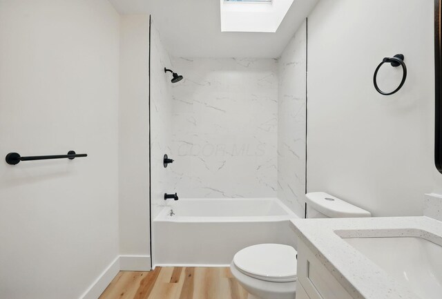 full bath featuring tub / shower combination, vanity, toilet, a skylight, and wood finished floors