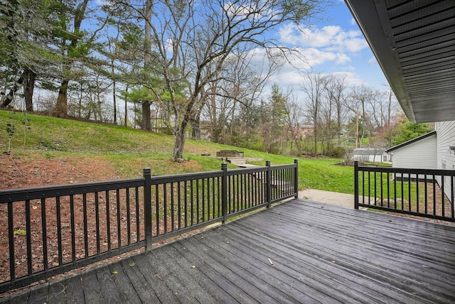wooden deck featuring a lawn