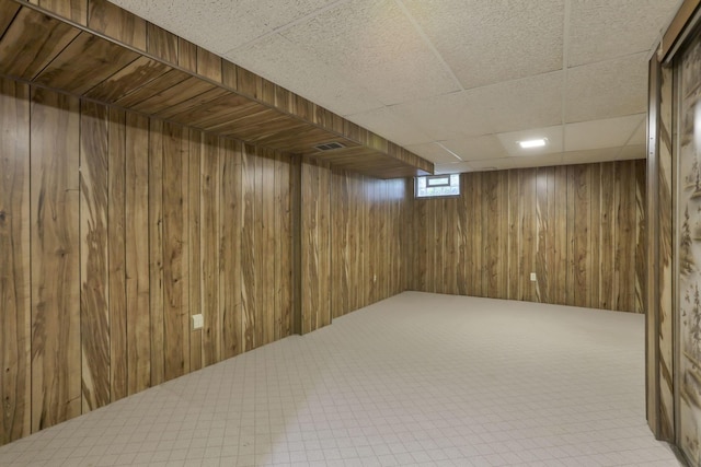 below grade area with wooden walls and carpet flooring
