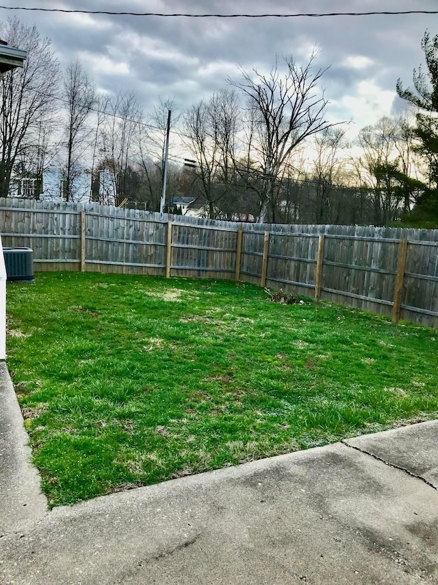 view of yard featuring central AC unit and a fenced backyard
