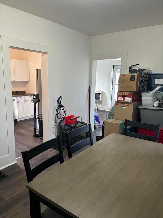 dining area featuring visible vents, a wall mounted AC, and dark wood finished floors