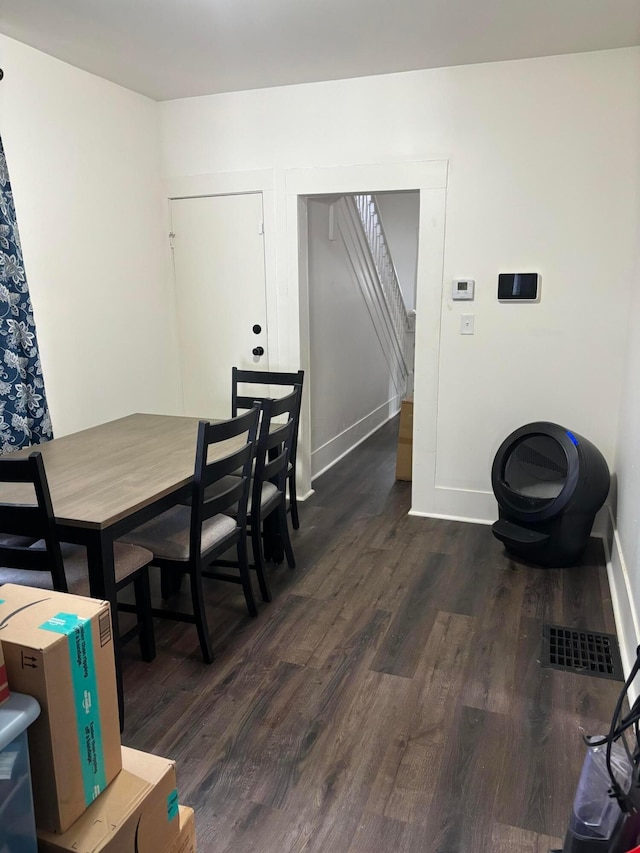 dining space featuring visible vents, baseboards, and dark wood finished floors