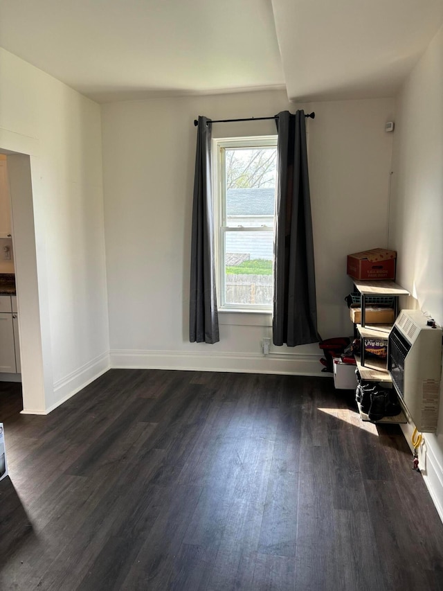 interior space featuring baseboards and dark wood finished floors