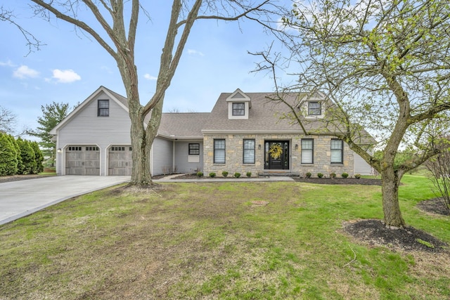 new england style home featuring concrete driveway, a shingled roof, a front lawn, and stone siding