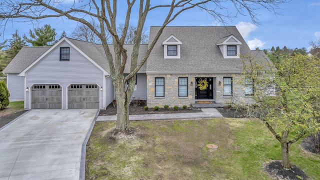 cape cod home featuring an attached garage, a shingled roof, concrete driveway, and stone siding