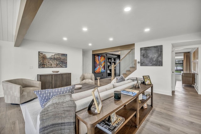 living area with baseboards, recessed lighting, and light wood-type flooring
