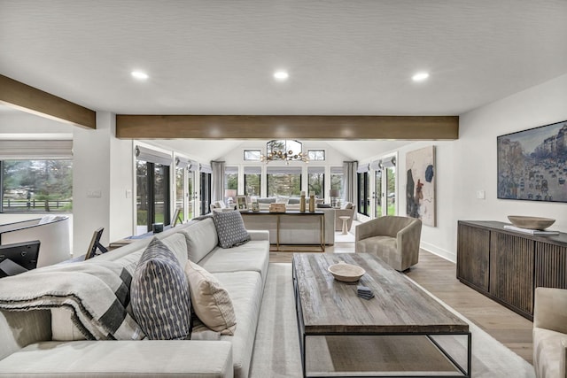 living area with a wealth of natural light, light wood-type flooring, lofted ceiling with beams, and a notable chandelier