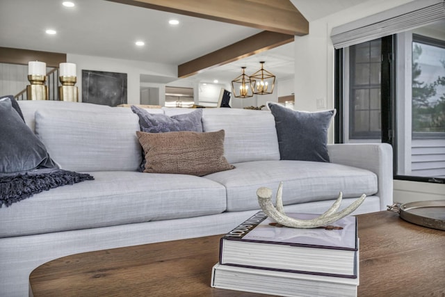 living area with recessed lighting, beamed ceiling, a notable chandelier, and wood finished floors
