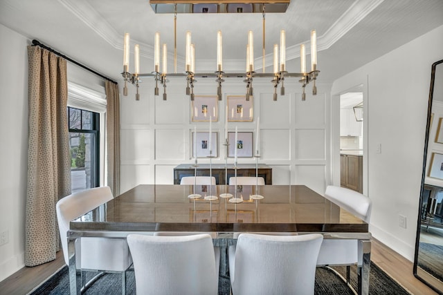 dining room featuring wood finished floors, a decorative wall, and baseboards