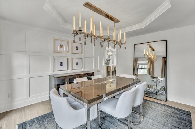 dining space with a decorative wall, crown molding, and a tray ceiling
