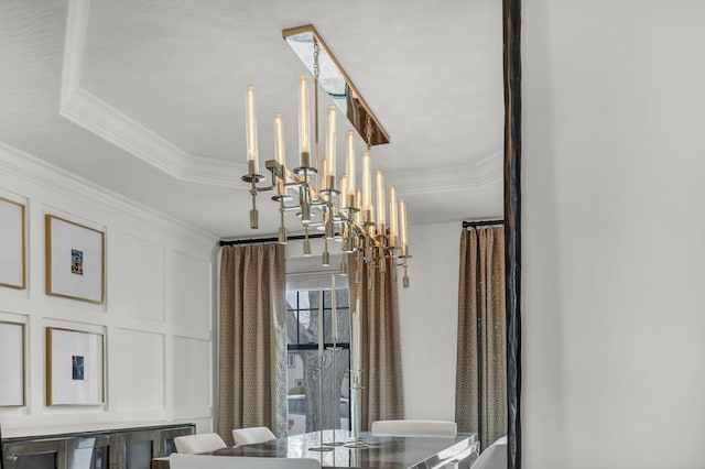 interior details featuring a chandelier, a decorative wall, and ornamental molding