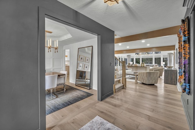 hall featuring light wood-type flooring, recessed lighting, a notable chandelier, and baseboards