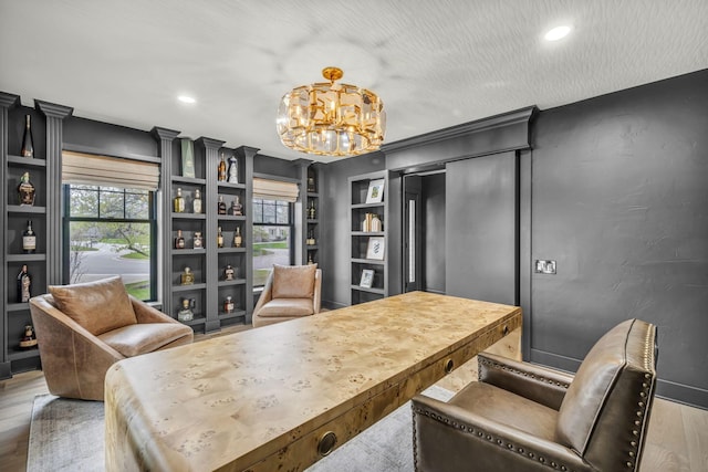 office featuring wood finished floors, a chandelier, recessed lighting, and built in shelves