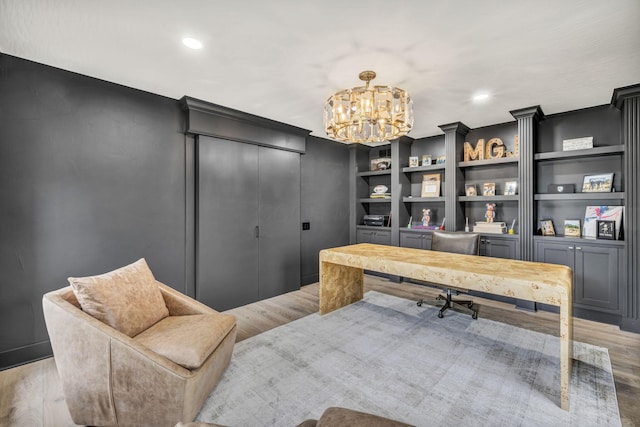 office featuring wood finished floors, recessed lighting, a notable chandelier, and built in features