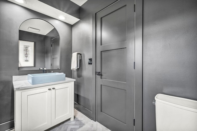 half bathroom featuring toilet and vanity