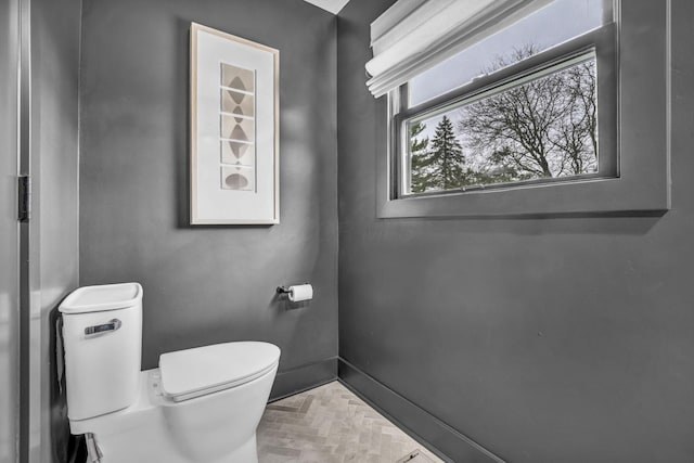 bathroom with toilet and baseboards
