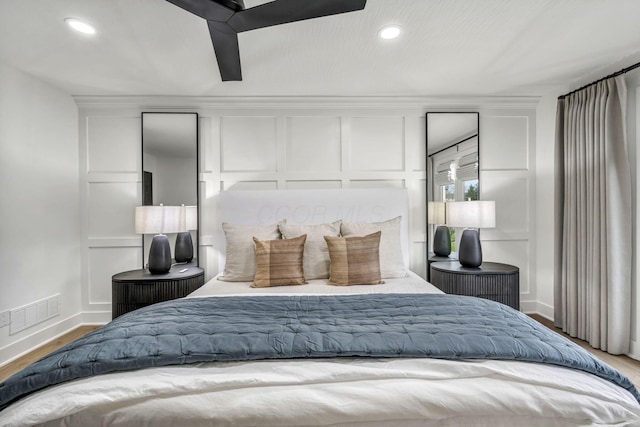 bedroom with baseboards, visible vents, wood finished floors, and recessed lighting