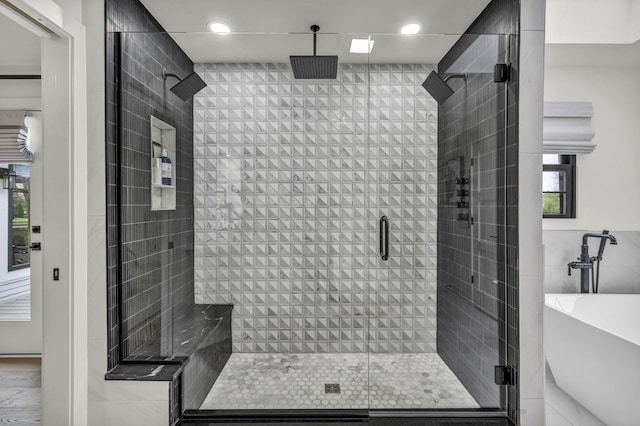 bathroom with recessed lighting, a freestanding tub, and a shower stall