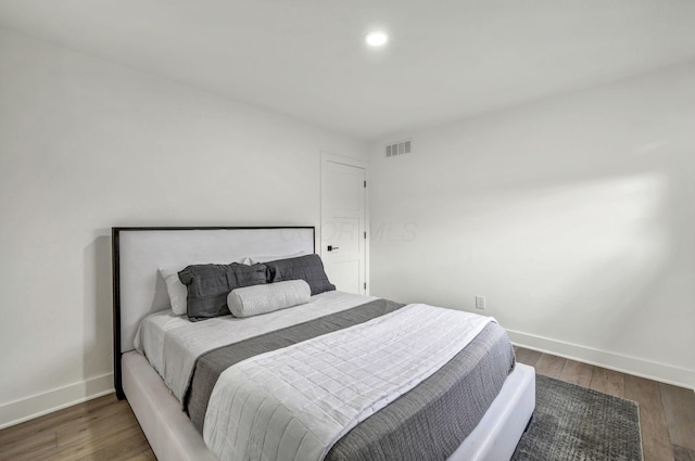 bedroom featuring baseboards, visible vents, wood finished floors, and recessed lighting