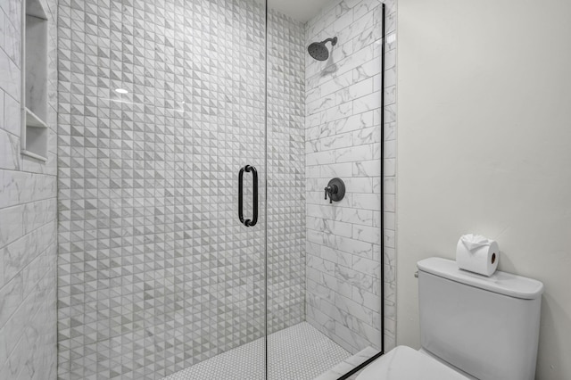 bathroom with a shower stall and toilet