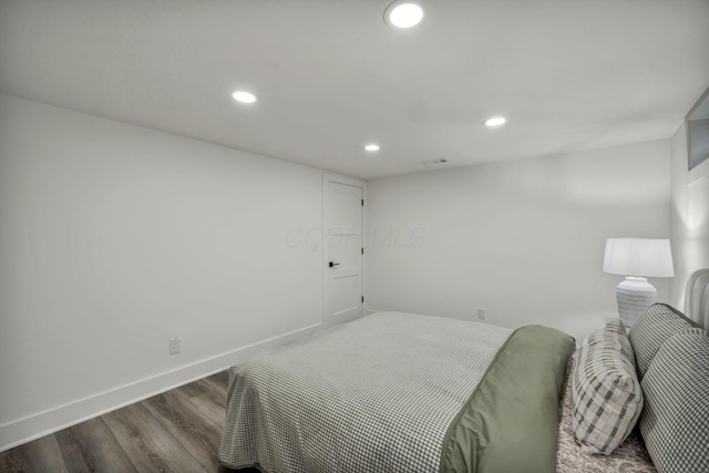 bedroom with recessed lighting, wood finished floors, and baseboards