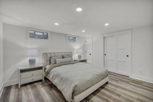 bedroom featuring recessed lighting, a closet, wood finished floors, and baseboards
