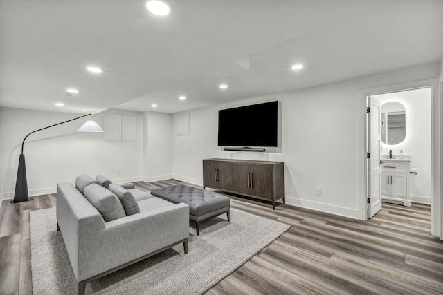 living area with baseboards, recessed lighting, and wood finished floors