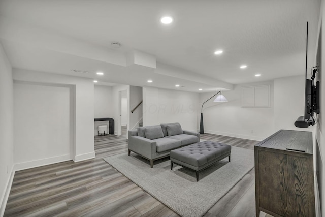 living room with recessed lighting, stairway, and wood finished floors