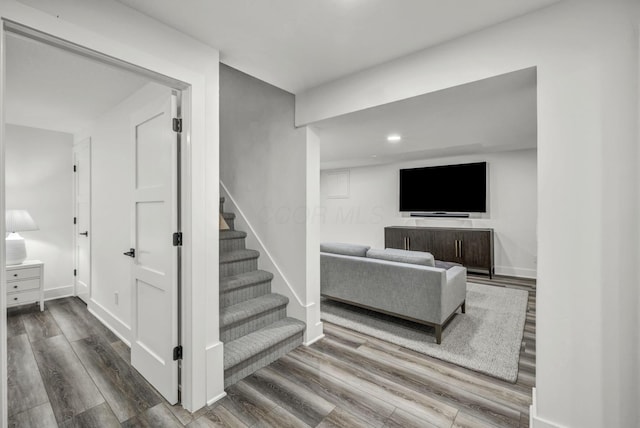 staircase featuring recessed lighting, wood finished floors, and baseboards