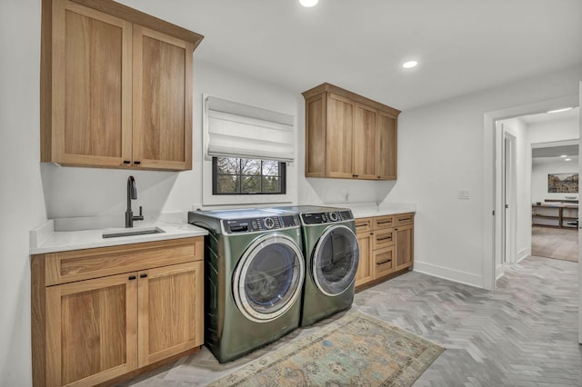 washroom featuring recessed lighting, a sink, cabinet space, separate washer and dryer, and baseboards