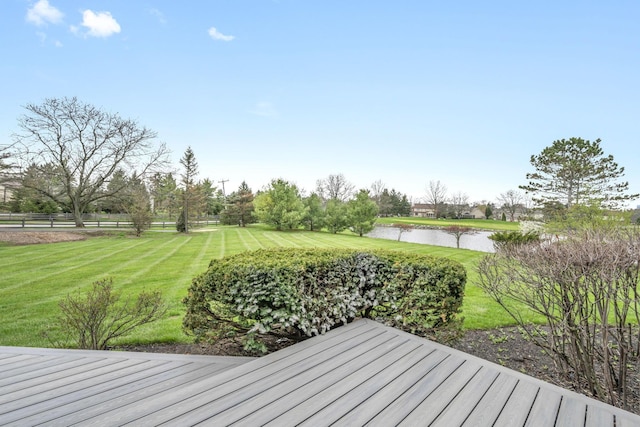 deck with a lawn, a water view, and fence