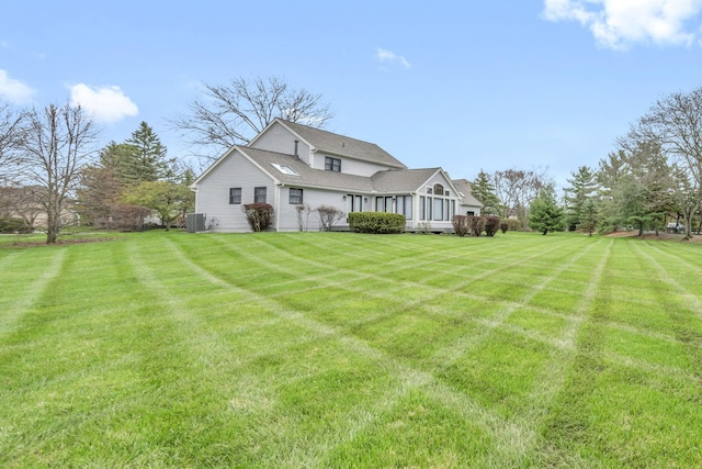 exterior space with central AC unit and a yard