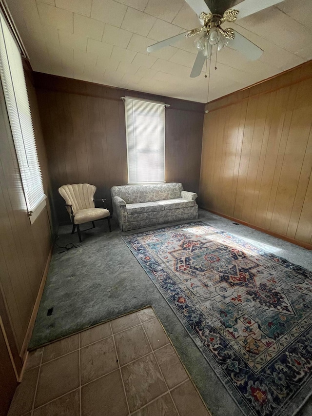 334 N High St, Caledonia, OH 43314 - sitting room featuring carpet flooring, tile patterned floors, wooden walls, and ceiling fan