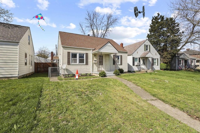 bungalow with fence and a front lawn