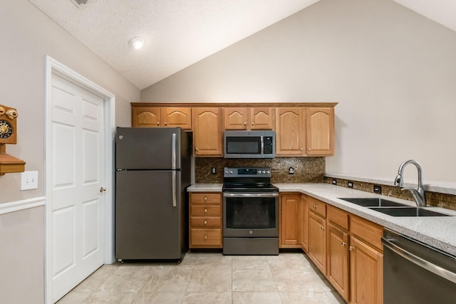3673 Stoneway Pt, Powell, OH 43065 - kitchen featuring stainless steel appliances, a sink, vaulted ceiling, backsplash, and light countertops