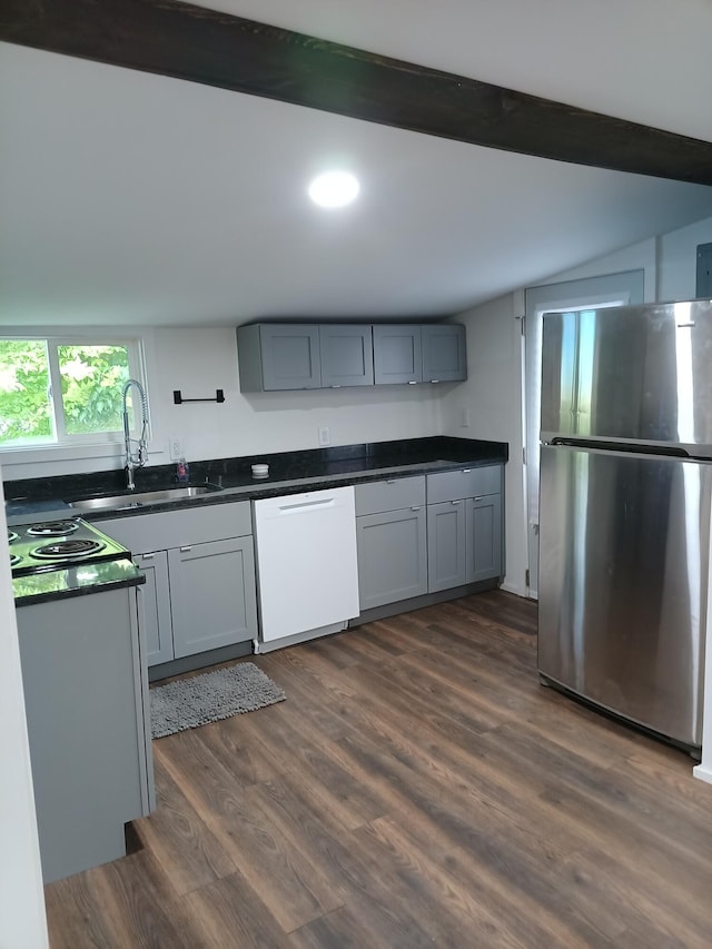 126 7th St, Lancaster, OH 43130 - kitchen with freestanding refrigerator, white dishwasher, a sink, dark countertops, and dark wood-style floors