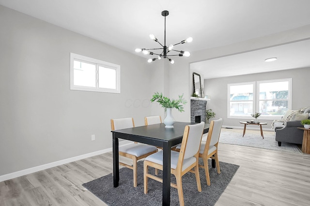 dining area with a chandelier, light wood-type flooring, and baseboards