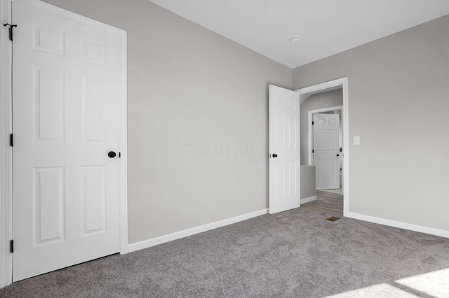 unfurnished bedroom featuring carpet flooring and baseboards