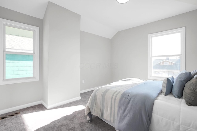 bedroom with visible vents, baseboards, carpet, and vaulted ceiling
