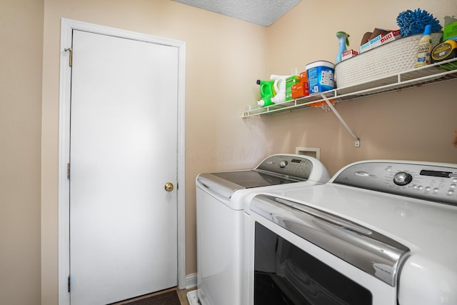 laundry area featuring laundry area, a textured ceiling, and washer and clothes dryer