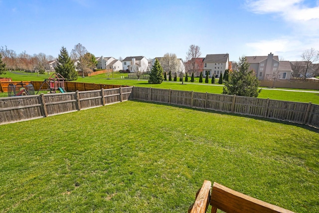 view of yard featuring a fenced backyard and a residential view