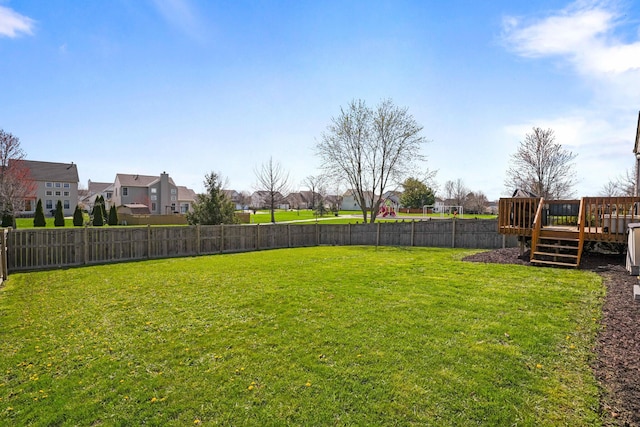 view of yard featuring a residential view, a fenced backyard, and a wooden deck