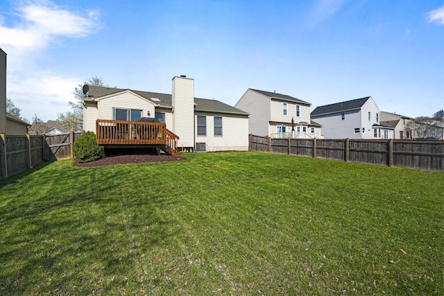 rear view of house featuring a residential view, central air condition unit, a fenced backyard, a yard, and a deck