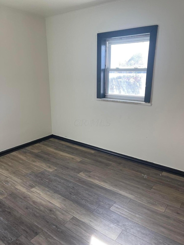 empty room featuring baseboards and wood finished floors