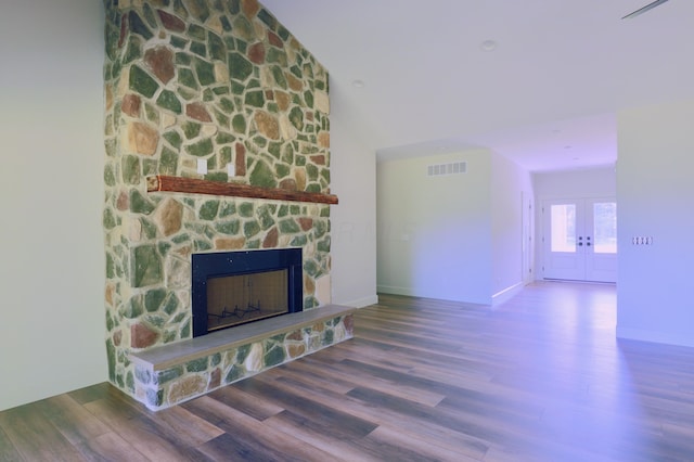 3597 Country Club Rd SW, Lancaster, OH 43130 - unfurnished living room featuring a stone fireplace, wood finished floors, french doors, and lofted ceiling