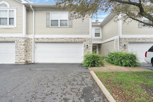 4899 Common Market Pl, Dublin, OH 43016 - view of property with stone siding, a garage, and driveway